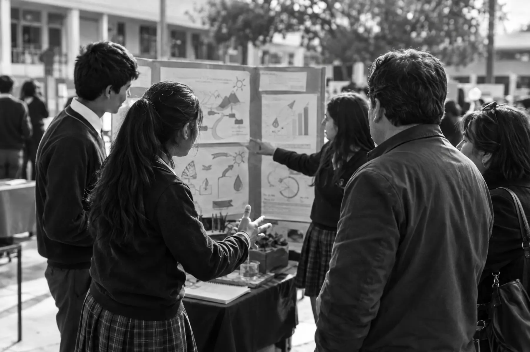 Estudiantes de enseñanza media presentan un proyecto comunitario en una feria escolar